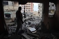 イスラエル軍による人質救出作戦で損傷した建物と散乱したがれきの中に立つ男性。パレスチナ自治区ガザ地区中部ヌセイラット避難民キャンプで（2024年6月9日撮影）。(c)EYAD BABA / AFP