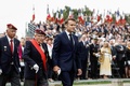 仏北西部プリュムレックで行われた、ノルマンディー上陸作戦から80年を記念した式典に参加したエマニュエル・マクロン大統領（中央）と自由フランス軍の最後の生存者アシル・ミュレル氏（左隣、2024年6月5日撮影）。(c)Benoit Tessier / POOL / AFP