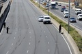 オーストラリア・メルボルン郊外で、高速道路に転がった事故機の部品を撮影する警官（2017年2月21日撮影）。(c)AFP/Mal Fairclough