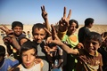 イスラム過激派組織「イスラム国（IS）」から奪還されたイラク北部ハウィジャの南部郊外で、勝利を表すVサイン示す子どもたち（2017年10月6日撮影、資料写真）。(c)AFP/AHMAD AL-RUBAYE