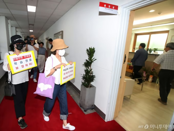 慶北大学本館前で「医学生の休学禁止撤回」「学習権の保障」を求めるプラカードを掲げる医学生の親たち(c)news1