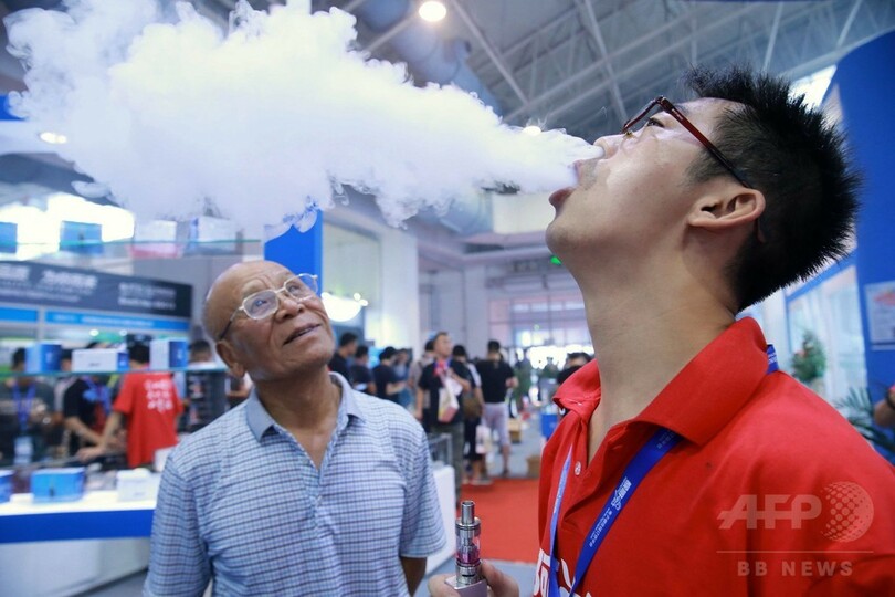美女も豪快に鼻から「ふーっ」、中国・電子たばこ展示会