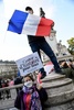 フランス・パリで、殺害された歴史教師のサミュエル・パティさんを追悼し「全員に歴史の授業を」と書かれたプラカードを持つ女性（下）と仏国旗を掲げる男性（2020年10月18日撮影）。(c)Bertrand GUAY / AFP