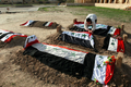 写真はアウジャで14日、イラク国旗に覆われたフセイン父子、元側近らの墓。(c)AFP/DIA HAMID