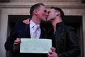 英ロンドン（London）で挙式した後に結婚証明書を掲げキスをするティム・ジャーメイングローブズ（Tim Jarmaine-Groves）さん（左）とリチャード・ジャーメイングローブズ（Richard Jarmaine-Groves）さん（2014年3月29日撮影）。(c)AFP/CARL COURT