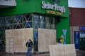 ハリケーン「ウィラ」が接近したメキシコ・シナロア州マサトランで、店舗を板で補強する作業員ら（2018年10月22日撮影）。(c)AFP