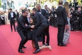 仏カンヌ国際映画祭のレッドカーペットに裸で乱入し、警備員に取り押さえられる女性（2022年5月20日撮影）。(c)Valery HACHE / AFP