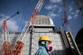 福島第一原子力発電所の3号機原子炉の前を歩く東京電力の従業員（2018年1月31日撮影）。(c)AFP PHOTO / Behrouz MEHRI