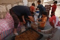 シリア北西部イドリブ県の町ハーレムにある避難民キャンプで、キノコ栽培用のぬれた干し草を袋に詰めるナスララさん（2019年11月29日撮影）。(c)Aaref WATAD / AFP