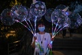 中国・湖北省武漢の長江近くで、風船を売る女性（2020年8月4日撮影）。(c)Hector RETAMAL / AFP