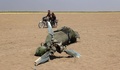 シリアのアレッポ県とイドリブ県の境界付近で墜落したロシア軍の輸送ヘリ「ミル8」の残骸のそばをバイクで通る男性らを写したとされる写真（2016年8月1日撮影）。(c)AFP/Mohamed al-Bakour