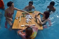 中国南西部・重慶（Chongqing）市内のプールでマージャンを楽しむ人々（2014年7月9日撮影）。(c)AFP
