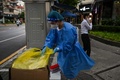 中国・上海の路上で新型コロナウイルスの検査を実施する医療従事者（2022年8月16日撮影、資料写真）。(c)Hector RETAMAL / AFP