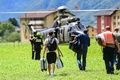 スイス・ロベレドの救護拠点から飛び立つヘリコプターに向かう避難住民ら（2024年6月22日撮影）。(c)Piero CRUCIATTI / AFP