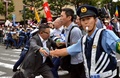 参院平和安全法制特別委員会が横浜市で開いた地方公聴会の会場前で、特別委の委員が乗った車を止めようとする人たちを押しとどめようとする警官ら（2015年9月16日撮影）。(c)AFP/Yoshikazu TSUNO