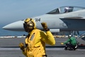 大西洋を航行する米空母ジョージ・H・W・ブッシュの甲板で、米海軍のF18戦闘機「ホーネット」を誘導して離艦させるカタパルト担当のナイジェル氏（左、2018年5月11日撮影）。(c)AFP / Eric Baradat