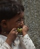 パキスタン・カラチのスラム街で、ハエが群がる中でブドウを食べる子ども（2019年9月2日撮影）。(c)ASIF HASSAN / AFP