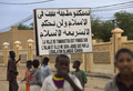 西アフリカ・マリに軍事介入した仏軍とマリ政府軍は28日、世界遺産都市トンブクトゥ（Timbuktu）を10か月にわたって実効支配していたイスラム武装勢力から奪還した。トンブクトゥ入りした両軍は、解放された住民の歓迎を受けた。

イスラム武装勢力掃討のため北進していた両軍は26日、北部主要都市ガオ（Gao）を制圧。28日にはガオとトンブクトゥ間の全域を奪還した。イスラム武装勢力から奪還されていない都市は、首都バマコ（Bamako）北東1500キロに位置するキダル（Kidal）のみとなった。

国際社会から同地域への経済支援も届き始めている。日本政府は29日、邦人が犠牲となったアルジェリア天然ガス施設での人質事件を受け、マリを含む西アフリカ・サハラ砂漠南縁の安定化支援として1億2000万ドル（約110億円）の拠出を表明した。

写真はトンブクトゥでイスラム武装勢力が建てた「トンブクトゥはイスラムの上に築かれた都市であり、イスラムの法によってのみ裁かれる」と書かれた看板を背にした子どもたち（2013年1月28日撮影）。(c)AFP/ERIC FEFERBERG