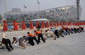 中国・北京（Beijing）の国家体育場（National Stadium）前で一列に並んで侵入防止用の柵を設置する作業員ら（2008年8月3日撮影）。(c)AFP/NICOLAS ASFOURI