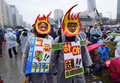 韓国ソウル中心部で行われた朴槿恵（パク・クネ）大統領の退陣を求める抗議デモに、ろうろくの仮装で参加する市民ら（2016年11月26日撮影）。(c)AFP/JUNG Yeon-Je