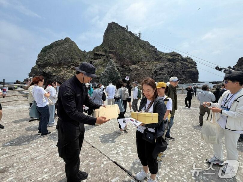 「独島」警備隊に児童生徒の手紙を渡す富川水州小学校のチョン・スギョン教諭＝東北アジア歴史財団提供(c)news1