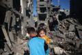 ガザ、10日間で子ども320人以上死亡 国連 パレスチナ自治区ガザ地区中部のヌセイラト難民キャンプで、前夜のイスラエルの空爆現場にたたずむパレスチナ人の子どもたち(2025年3月23日撮影)。(c)Eyad BABA/AFP