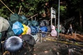 香港理工大学近くで、道路をふさいだバリケードの横を歩く男性（2019年11月15日撮影）。(c)ISAAC LAWRENCE / AFP
