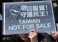 台湾・台北（Taipei）の総統府前で行われたデモで、「台湾は売り物じゃない」などと書かれたプラカードを掲げる参加者（2014年3月30日撮影）。(c)AFP/Mandy CHENG