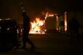 仏西部ナントで、炎上するトラックを見る男性（2023年7月1日撮影）。(c)Sebastien SALOM-GOMIS / AFP