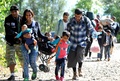 クロアチアとハンガリーの国境近くの駅から国境へ向けて歩く移民の家族（2015年9月21日撮影）。(c)AFP