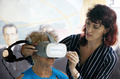 米フロリダ州マイアミのリトルハバナで、ニディア・シルバさん（左）に、バーチャルリアリティー（VR）ゴーグルをつけるアレクサンドラ・イワノビッチ氏（2019年7月26日撮影）。(c)RHONA WISE / AFP
