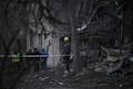 ウクライナの首都キーウで、ロシアの攻撃で損壊した住宅を訪れた自治体職員と警察官（2022年12月31日撮影）。(c)Genya SAVILOV / AFP
