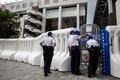 香港の新型コロナウイルス大規模検査に使用される体育館に設置されたゲートと警官（2020年8月28日撮影）。(c) ISAAC LAWRENCE / AFP