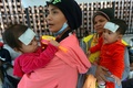 カンボジアの首都プノンペンの病院前に並ぶ親子（2015年2月13日撮影）。(c)AFP/TANG CHHIN SOTHY