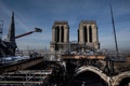 再建作業中の仏パリのノートルダム大聖堂で、クレーンのつりかごに乗って火災で溶けた足場を撤去する作業員ら（2020年11月24日撮影）。(c) Martin BUREAU / AFP