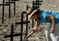 2008年2月1日、ブラジル・リオデジャネイロ（Rio de Janeiro）のコパカバーナ･ビーチ（Copacabana beach）で、賃上げを要求する警察官が立てた十字架に花を供える女性。(c)AFP/ANTONIO SCORZA