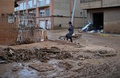 洪水に見舞われたスペイン東部バレンシア自治州で、ぬかるんだ通りを歩くバスローブ姿の女性（2024年11月1日撮影）。(c)Manaure Quintero / AFP