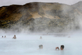 写真はアイスランドの首都レイキャビク（Reykjavik）郊外にある温泉｢ブルーラグーン（Blue Lagoon）｣を楽しむ観光客。ブルーラグーンは水の色が青と緑であることから、この名で呼ばれている。健康効果もうたわれている（2009年4月26日撮影）。(c)AFP/OLIVIER MORIN