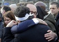 仏首都パリ（Paris）でテロに反対するため行われたデモ行進で、フランソワ・オランド（Francois Hollande）仏大統領（奥）と抱き合う風刺週刊紙シャルリー・エブド（Charlie Hebdo）のコラムニスト、パトリック・プル―（Patrick Pelloux）氏（2015年1月11日撮影）。(c)AFP/PHILIPPE WOJAZER