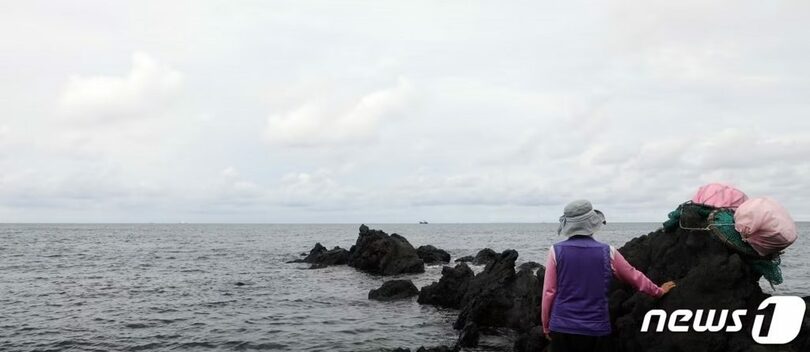 済州市・龍頭岩（ヨンドゥアム）近くの海岸で、海を見つめる海女(c)news1