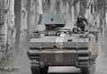 ウクライナ東部バフムート近くで、装甲兵員輸送車で移動する同国兵（2023年4月11日撮影）。(c)Genya SAVILOV / AFP