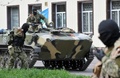 ウクライナ東部ドネツク（Donetsk）州スラビャンスク（Slavyansk）の親ロシア派の分離派勢力によって占拠された行政庁舎の前で、装甲車の周囲に集まる軍服を着た武装集団（2014年4月16日撮影）。(c)AFP/GENYA SAVILOV