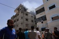 パレスチナ自治区ガザ地区中部デイルアルバラで、イスラエル軍がアパートを爆撃し、煙が上がるのを見つめるパレスチナ人（2024年6月8日撮影）。(c) Bashar TALEB / AFP