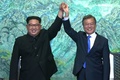 韓国と北朝鮮の軍事境界線上の板門店で、一緒に手を挙げる韓国の文在寅（ムン・ジェイン）大統領（右）と北朝鮮の金正恩（キム・ジョンウン）朝鮮労働党委員長（2018年4月27日撮影）。(cAFP PHOTO / KOREAN BROADCASTING SYSTEM
