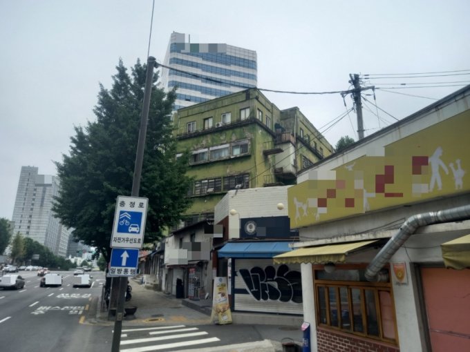 19日午前11時ごろの忠正アパートの様子。外壁の緑色ペイントが色あせ、黄色に染まったイチョウの葉のように見える。ソウル市は最近、この建物を撤去することを決めた(c)MONEYTODAY