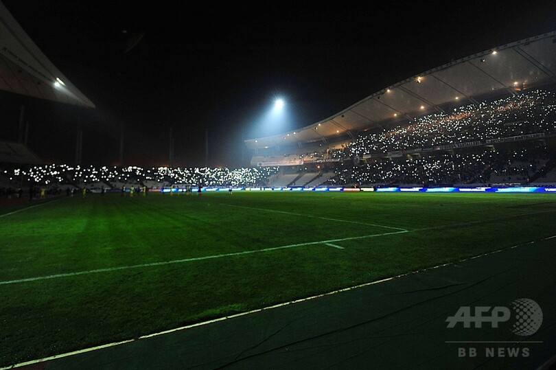 停電で試合が中断、ファンがライターや携帯電話で灯りをともす