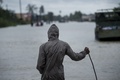 洪水に見舞われた米テキサス州ヒューストンで冠水した道路を眺める男性（2017年8月29日撮影）。(c)AFP/Brendan Smialowski