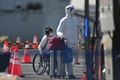 横浜・大黒ふ頭に停泊中のクルーズ船「ダイヤモンド・プリンセス」を下船した乗客（2020年2月21日撮影）。(c)Philip FONG / AFP