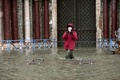 強い雨と風で「アクアアルタ」と呼ばれる高潮が発生したが可動式防潮堤「モーゼ（MOSE）」が稼働しなかったため水に漬かったイタリア・ベネチアのサンマルコ広場で写真を撮る人（2020年12月8日撮影）。(c)ANDREA PATTARO / AFP