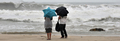 香港の浜辺で、台風の接近するなか、海を見るカップル（2008年8月22日撮影）。(c)AFP/Mike CLARKE